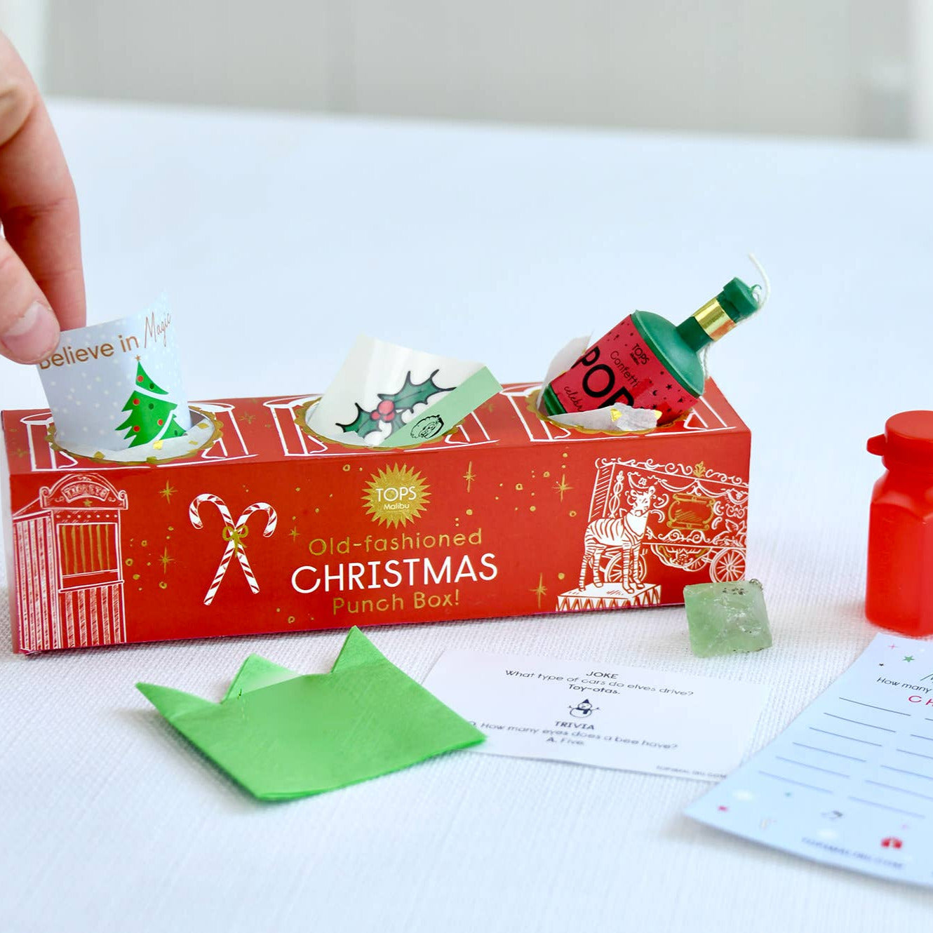 Red Christmas-themed punch box with festive decorations on a white surface.