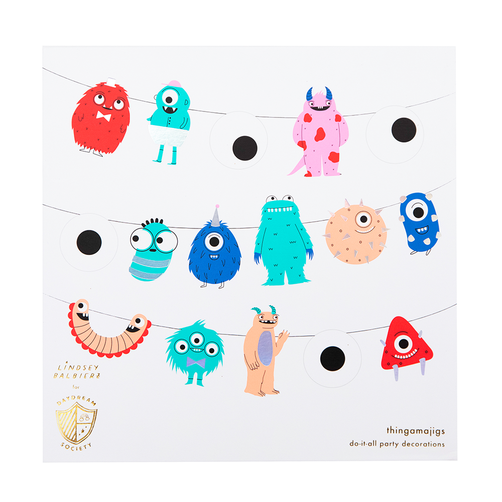 Colorful monster-themed party decorations hanging on a string against a white background.