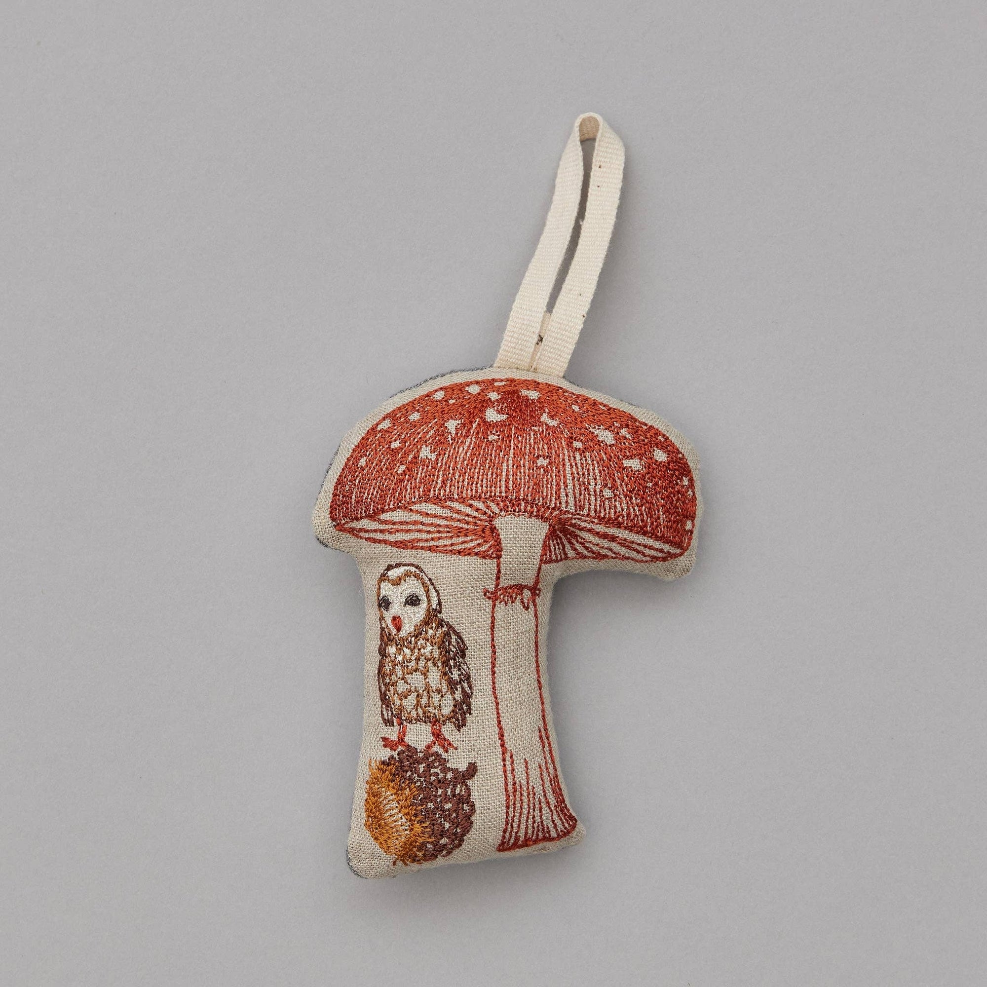 Fabric mushroom ornament with an owl design on a gray background