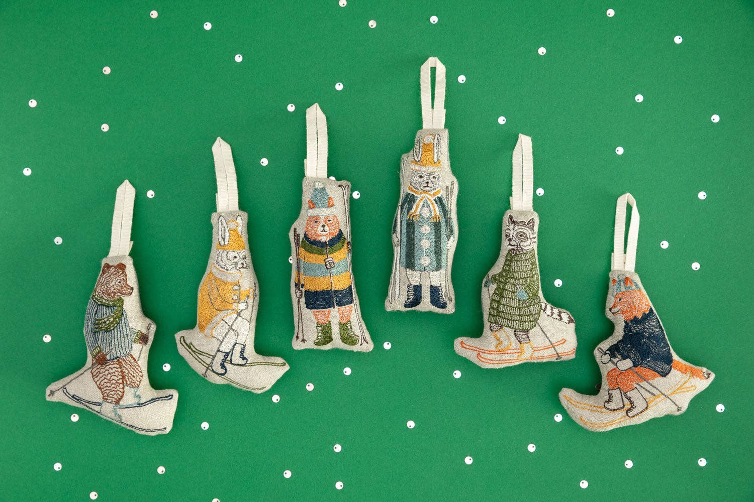 Set of decorative ornaments shaped like animals on a green background with white polka dots