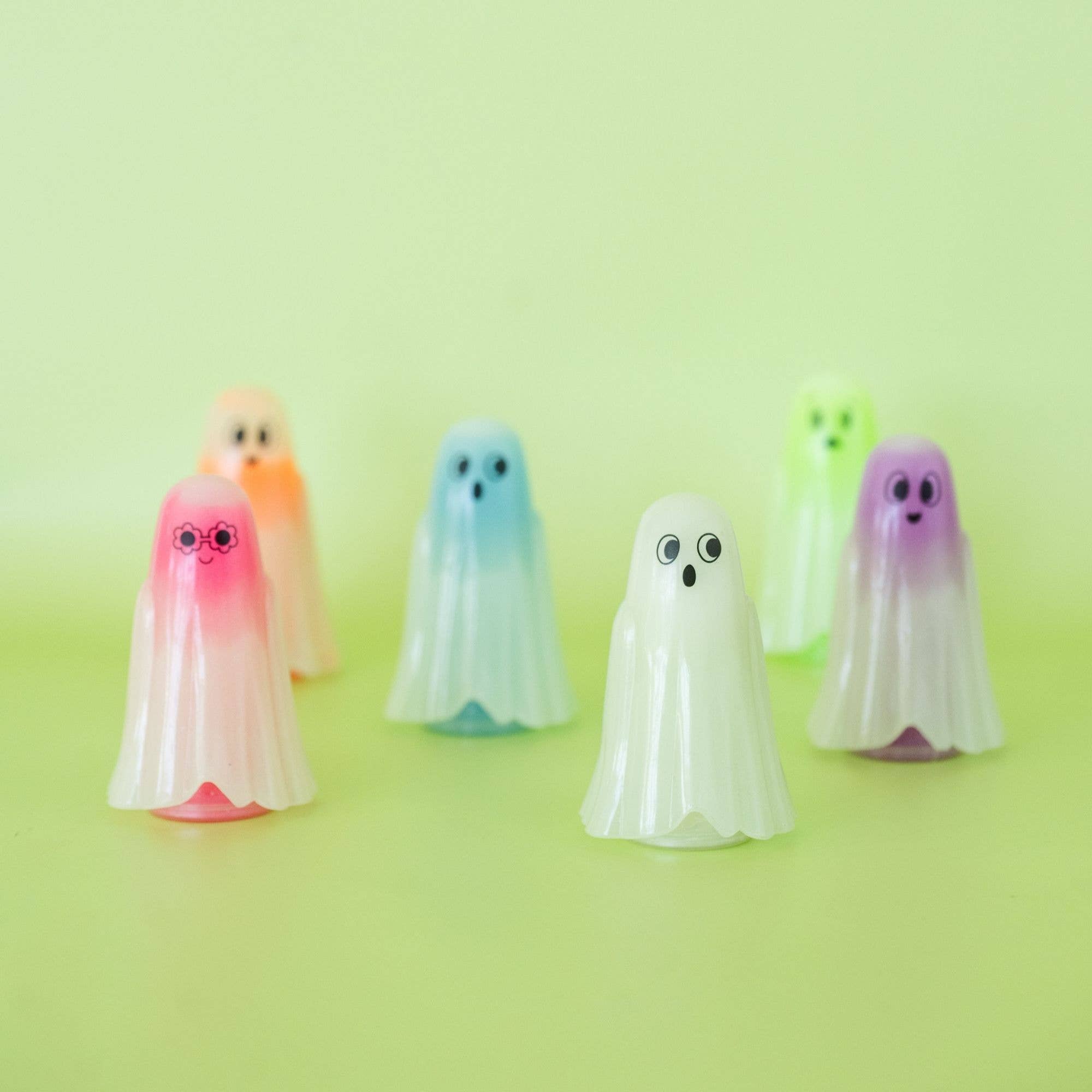 Colorful ghost-shaped objects on a green background