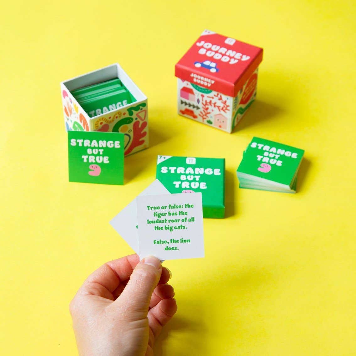 Colorful card game boxes and cards on a yellow background