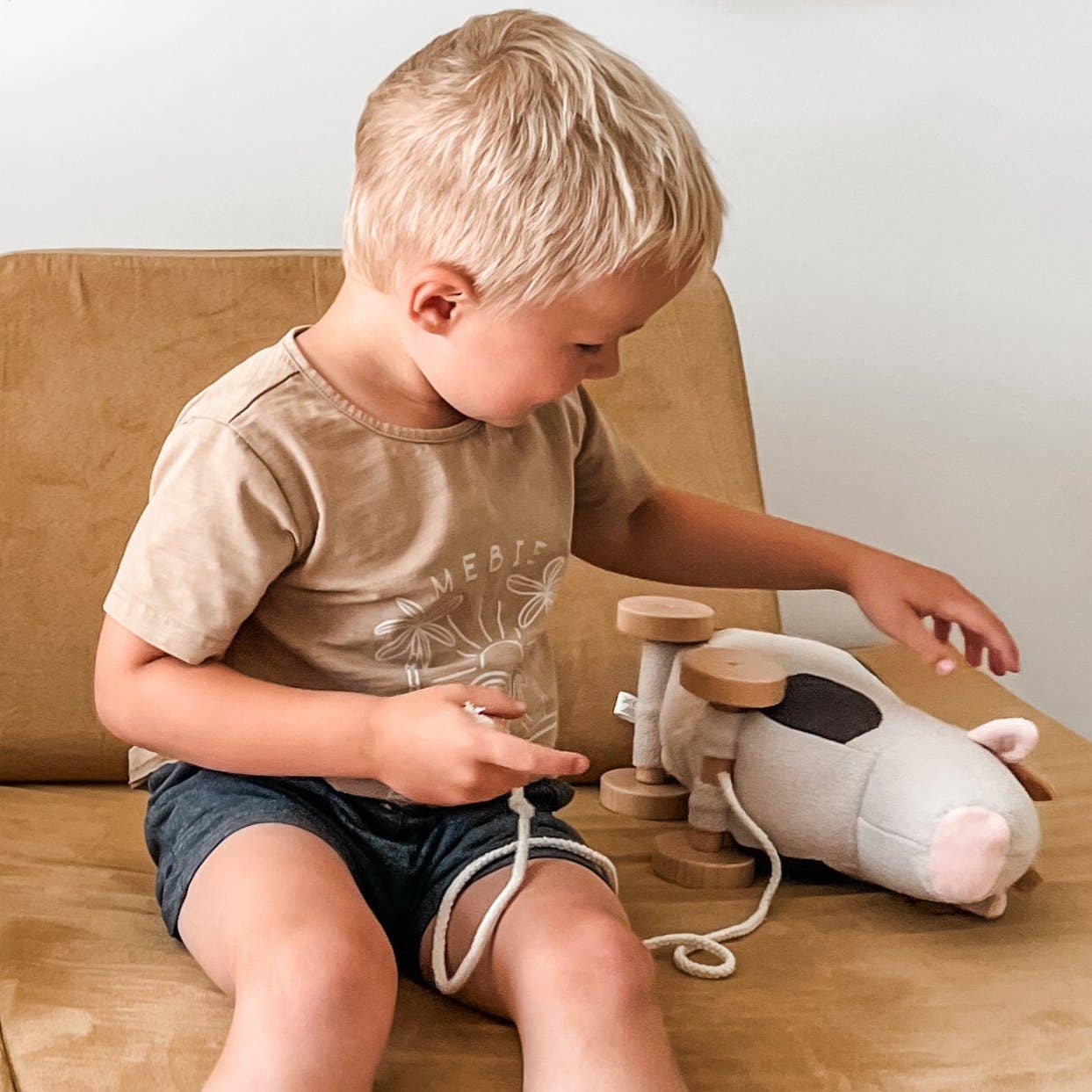 Child playing with a toy on a wooden floor