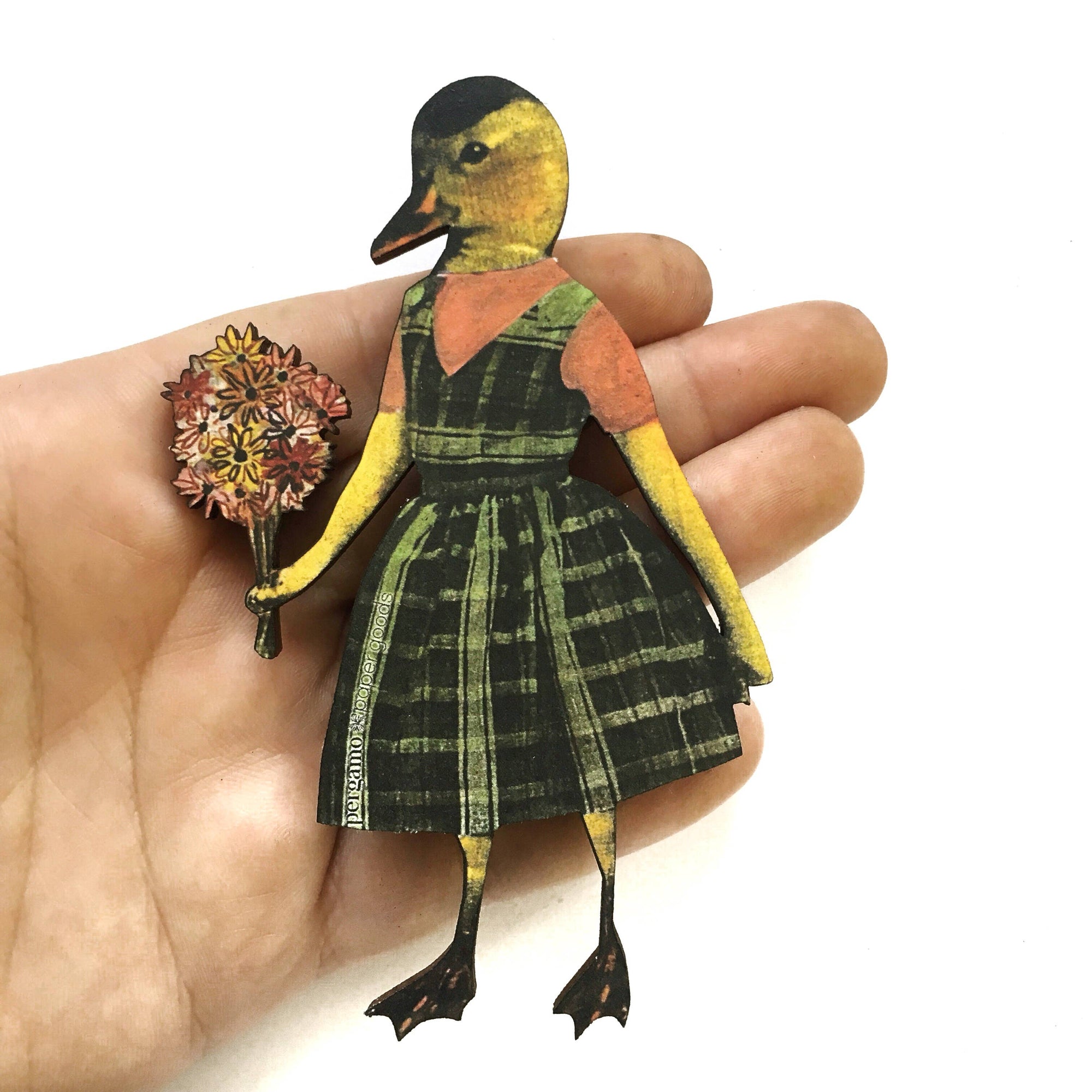 Hand holding a paper craft of a duck wearing a dress with a bouquet of flowers.