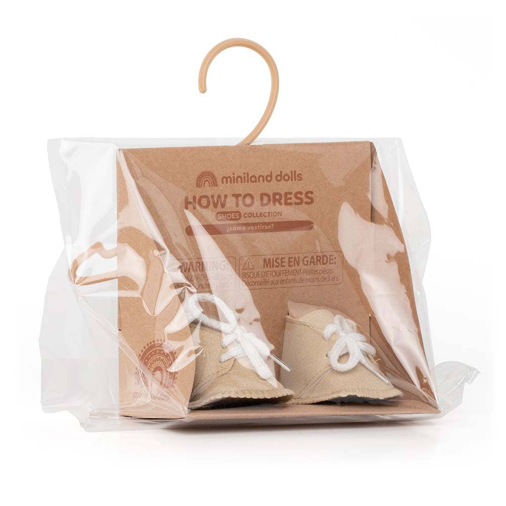 Packaged doll shoes with 'How to Dress' guide on a white background