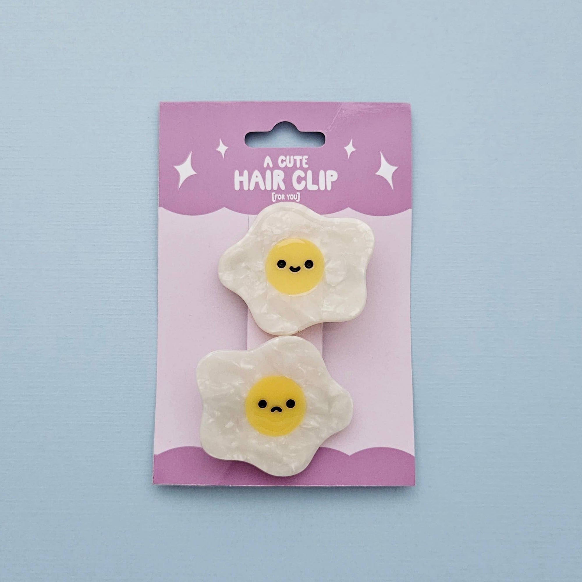 Hair clip packaging with two egg-shaped hair clips on a light blue background