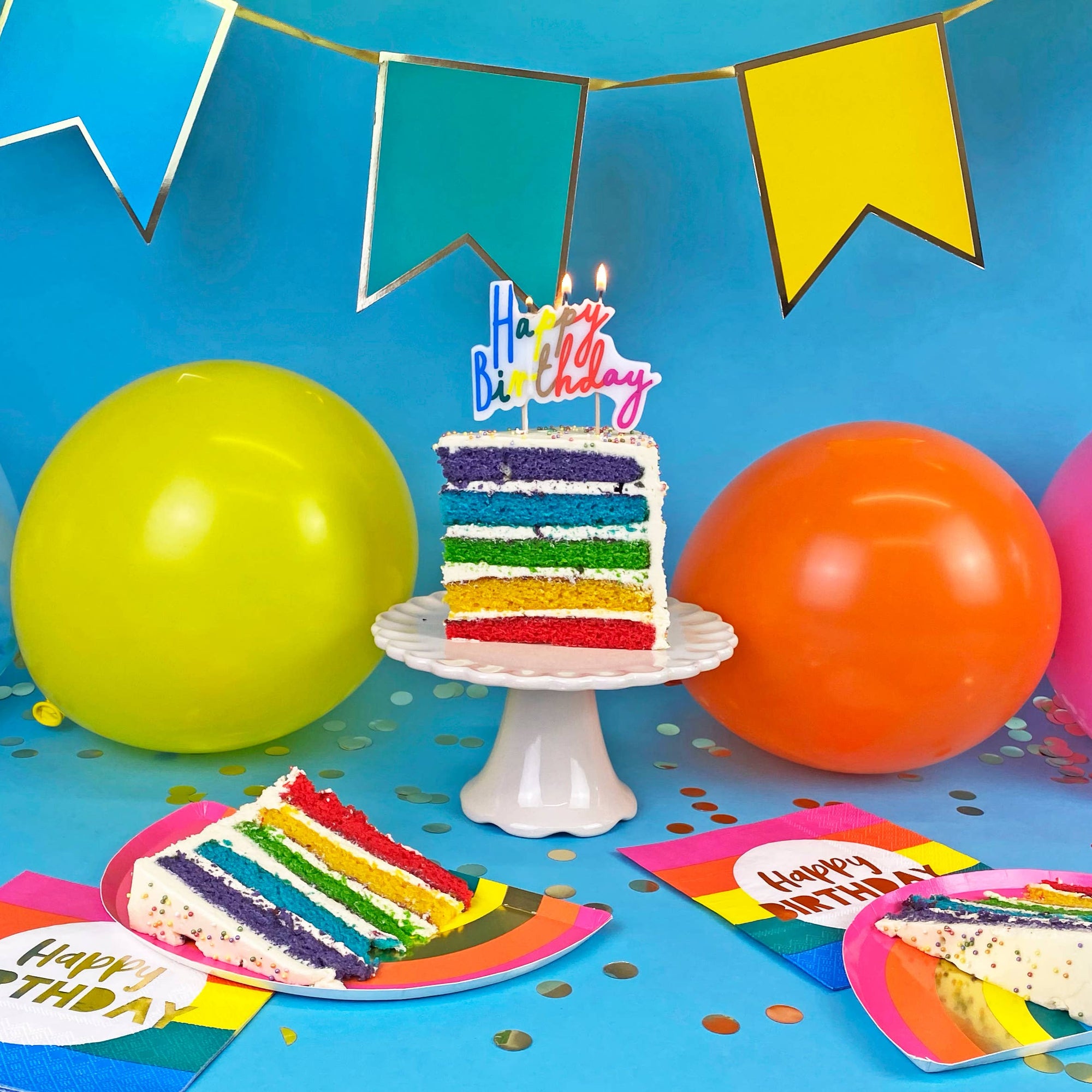 Birthday celebration with colorful cake, balloons, and decorations on a blue background