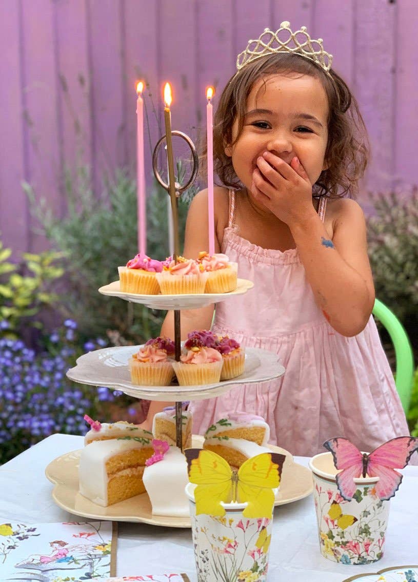 Child with a birthday cake and candles in an outdoor setting