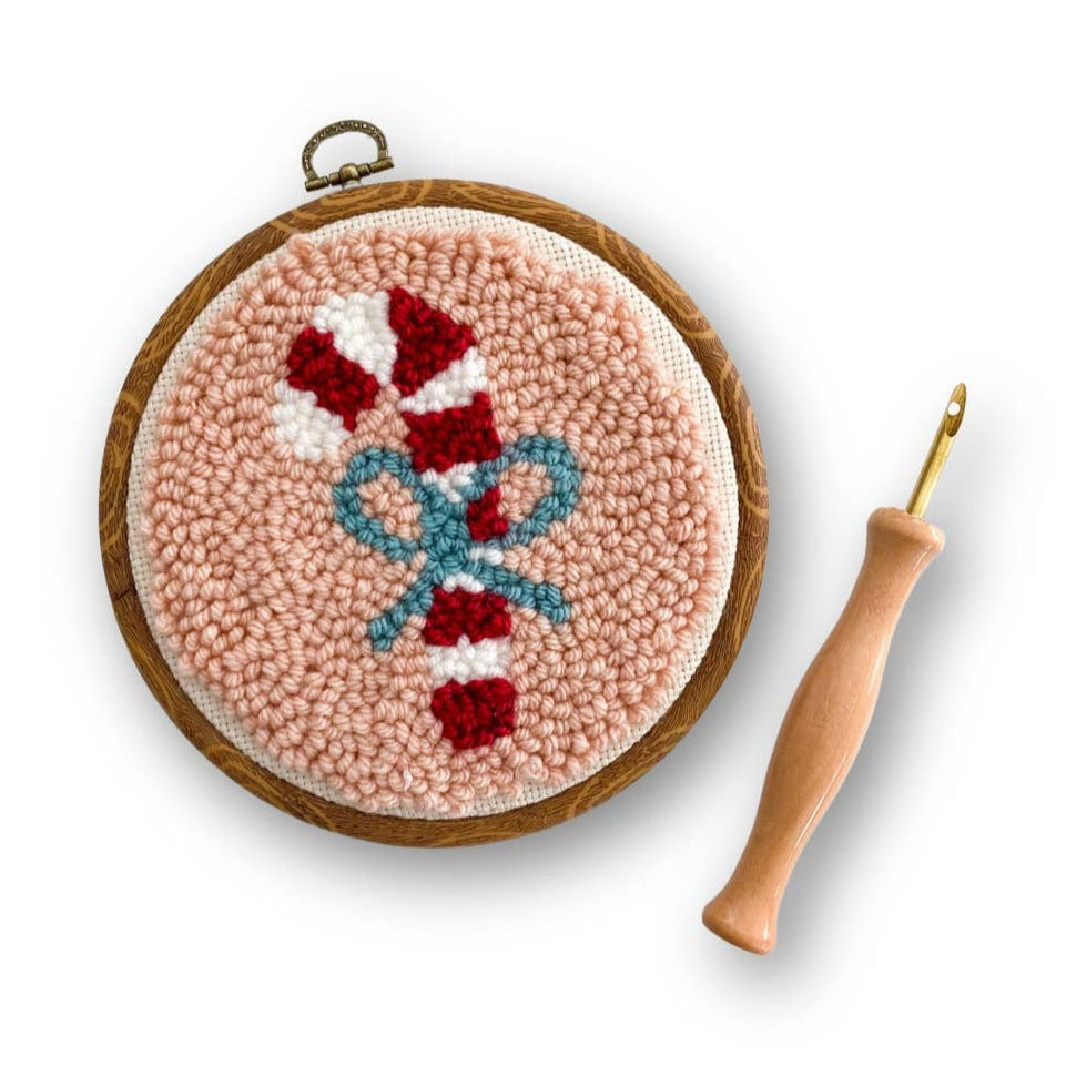 Embroidery hoop with a festive design and a crochet hook on a white background