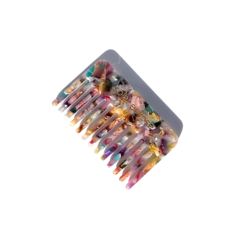 Colorful hair comb with decorative elements on a white background