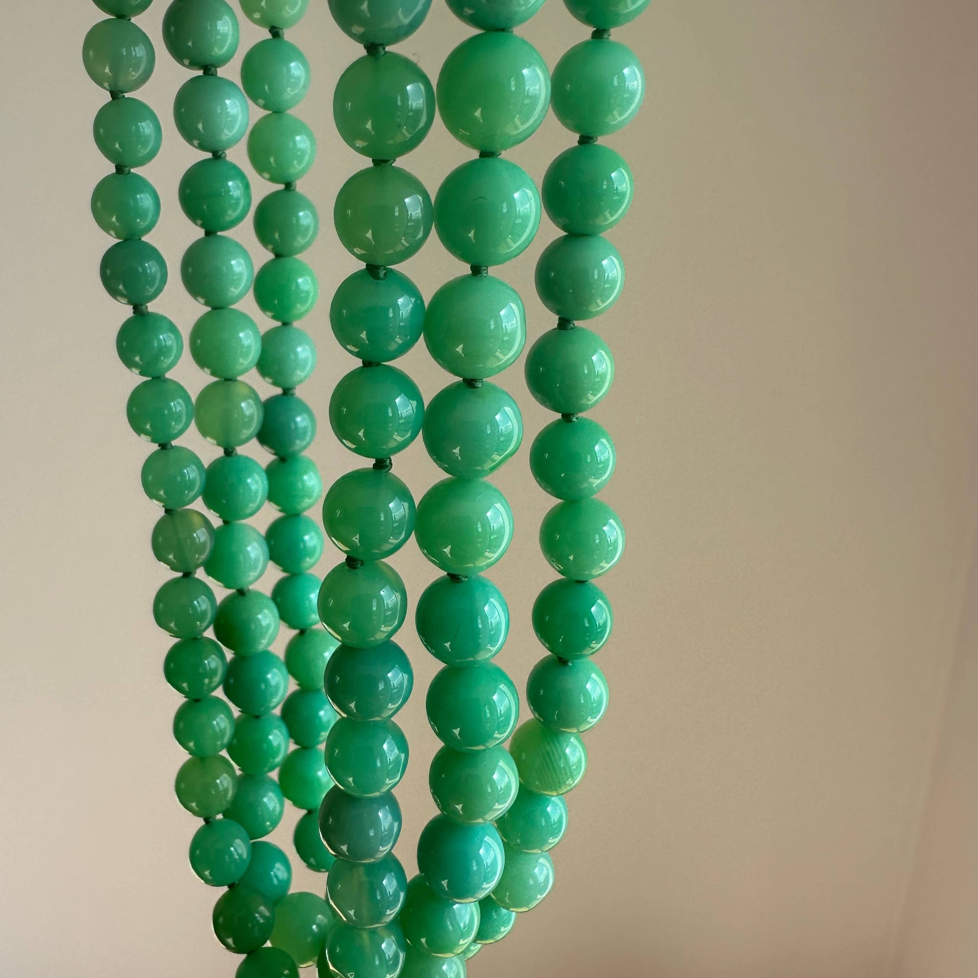 Green beaded necklace on a plain background