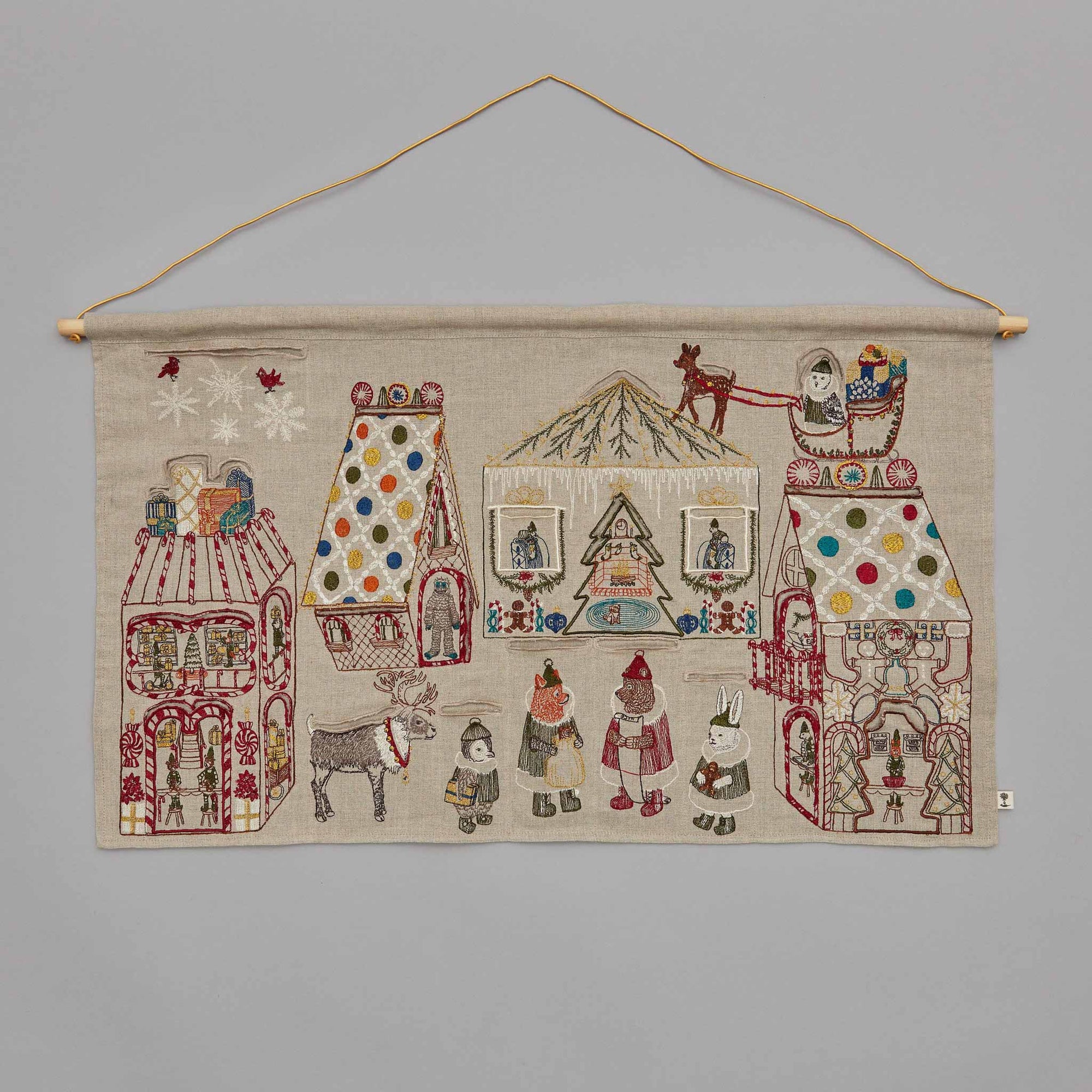 Decorative advent wall hanging with embroidered scenes and figures on a gray background