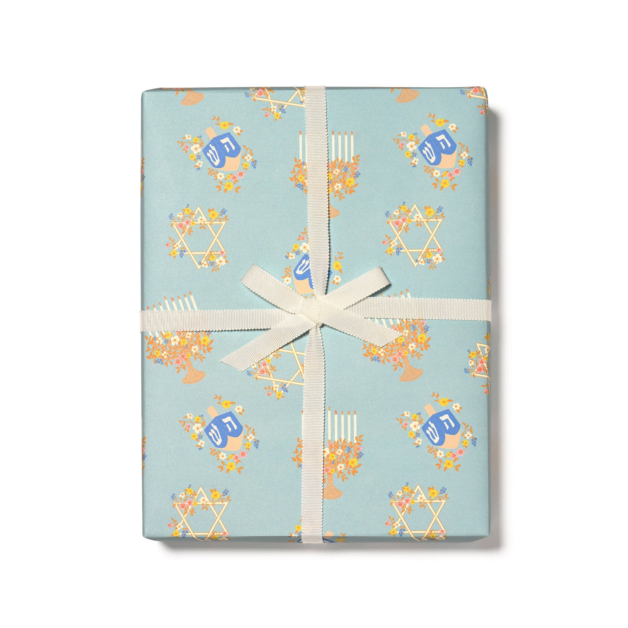 Gift wrap with star designs and a white ribbon on a light blue background