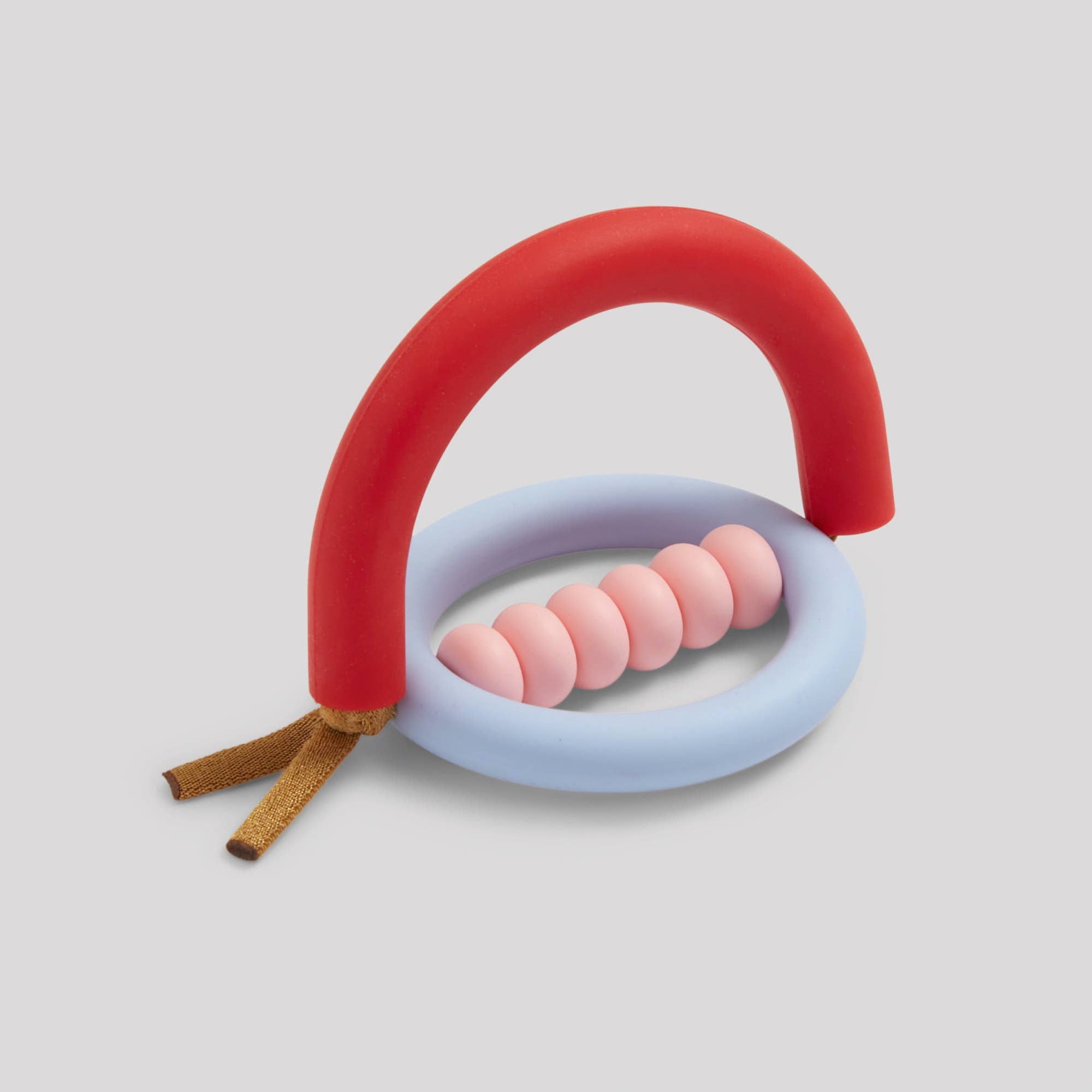 An abstract silicone teether in the shape of an arch with a red and blue color scheme and a wooden ring hanging from the bottom.