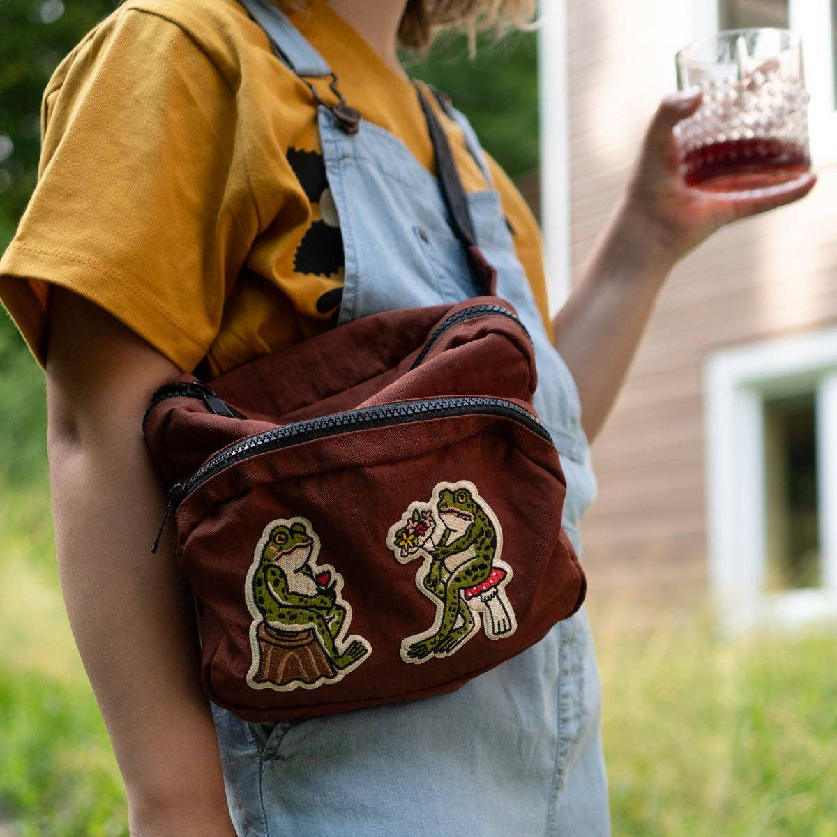 Person wearing a brown bag with embroidered designs outdoors