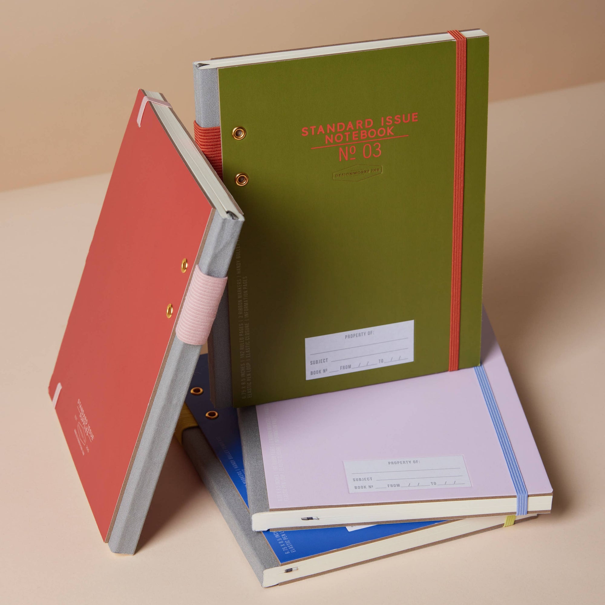 Stack of notebooks with different colored covers on a beige background