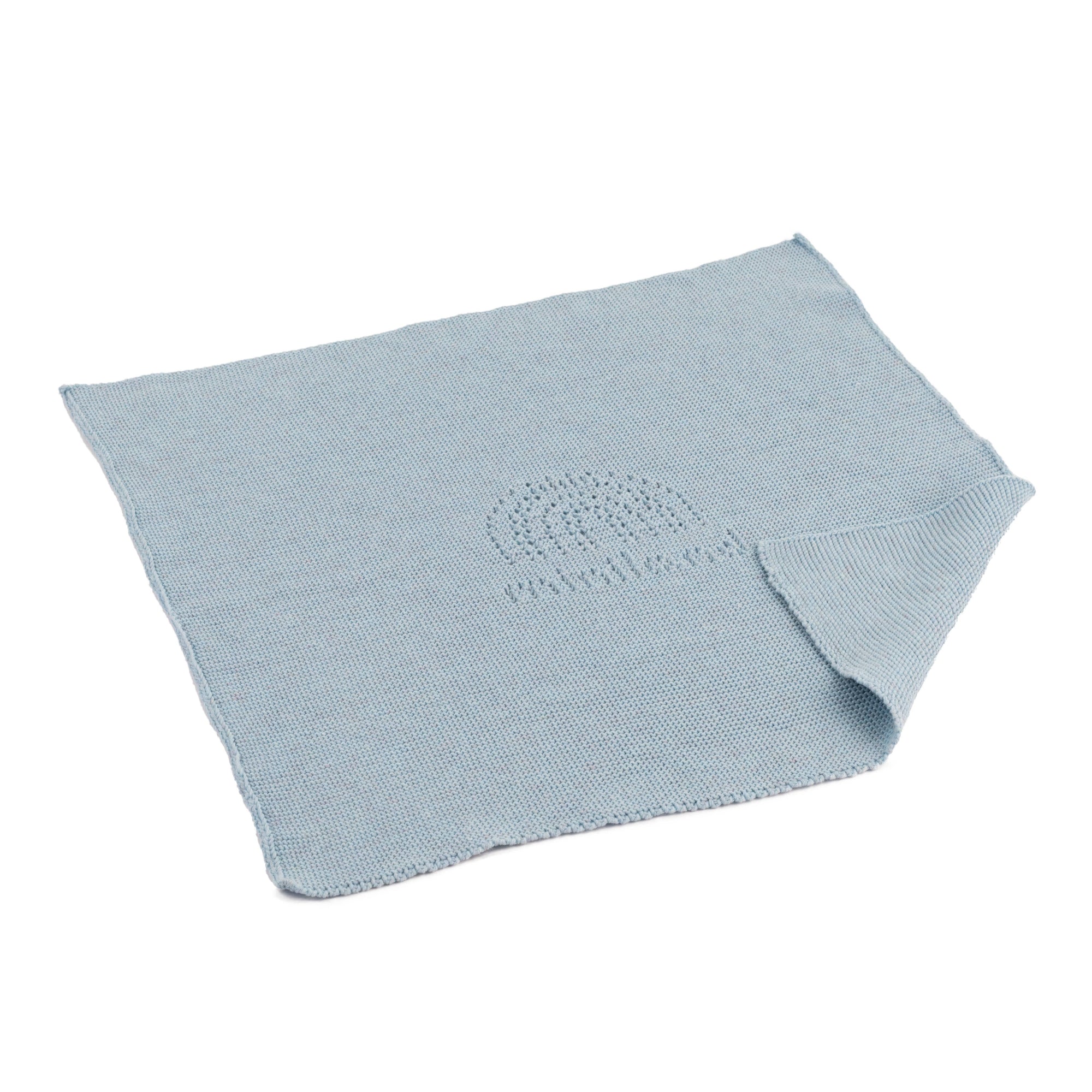 Light blue knitted blanket with a rainbow pattern on a white background