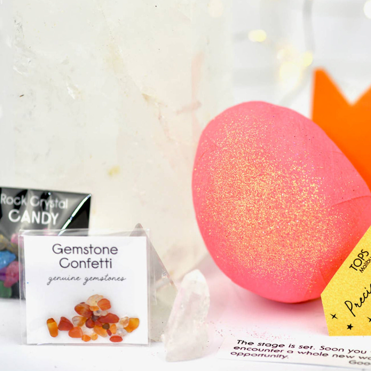Decorative pink surprise ball with a crown, candy, and confetti on a white background