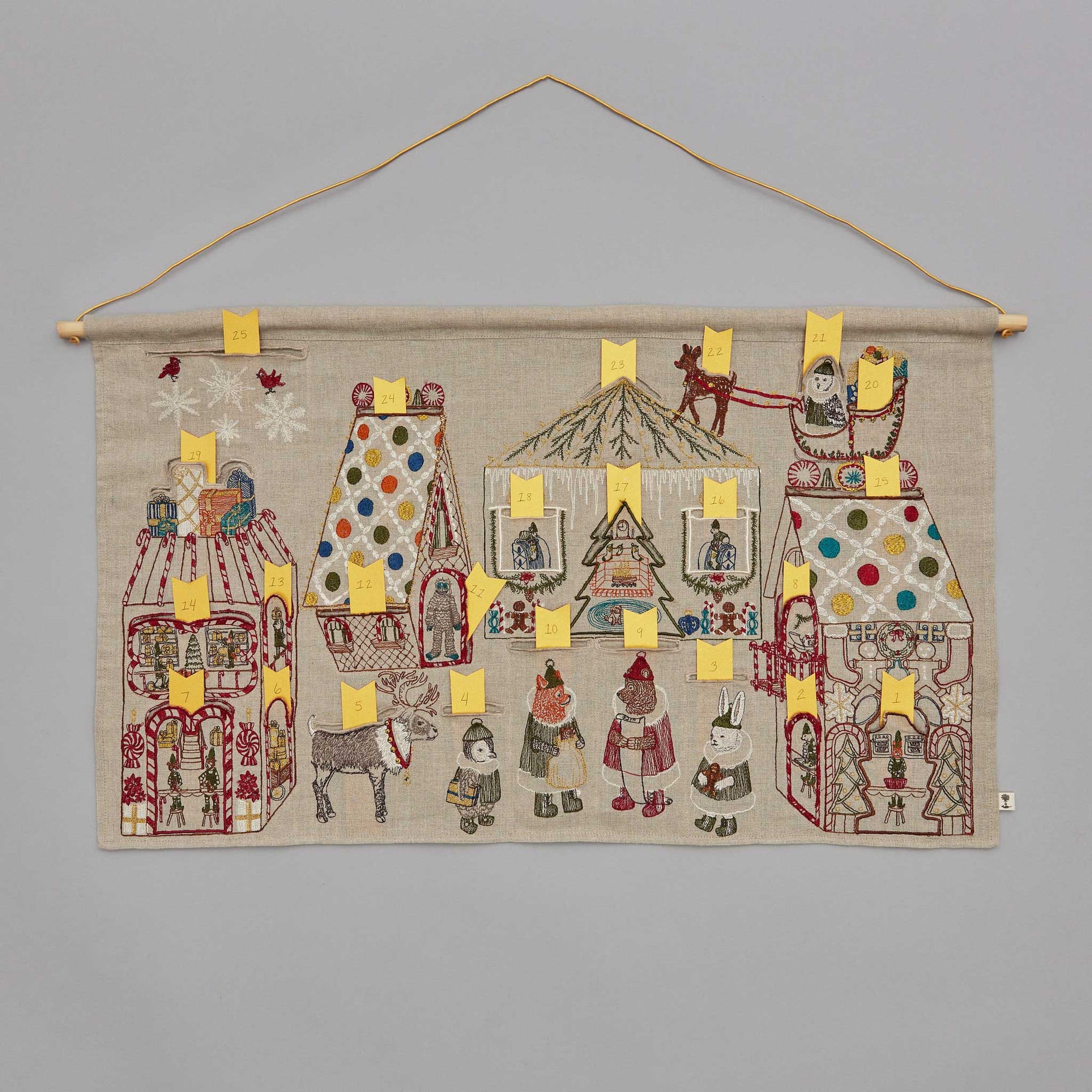 Decorative wall hanging with embroidered designs on a gray background