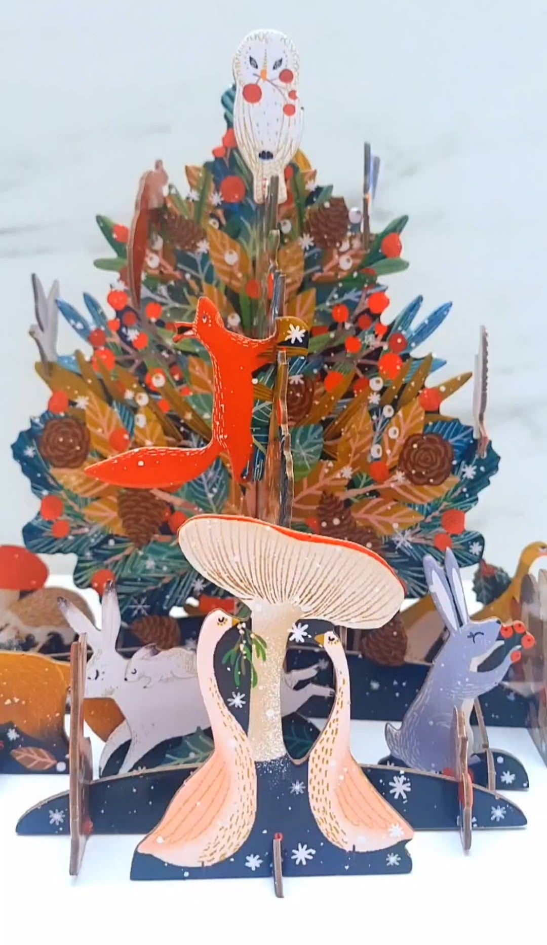 Decorative Christmas tree with animal figures on a white background