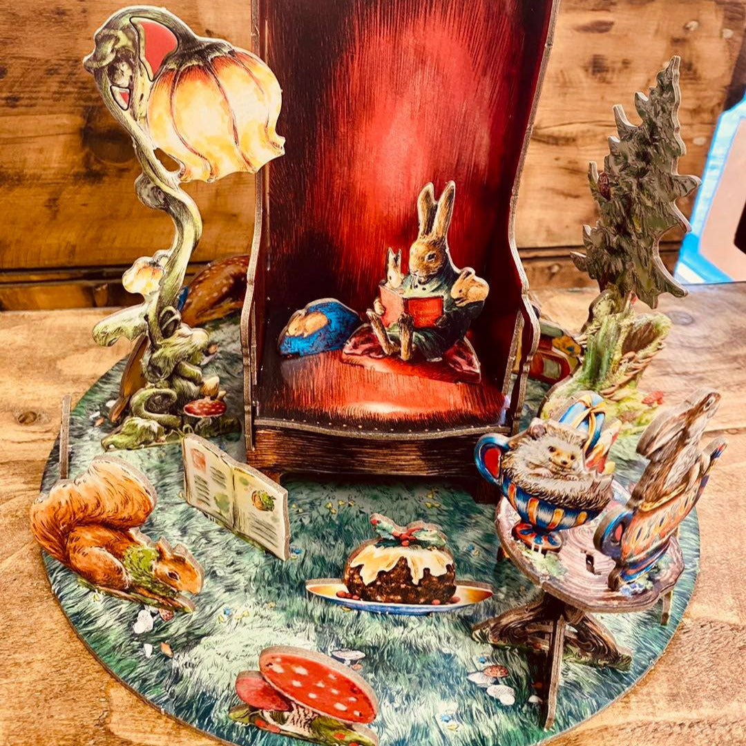 Wooden rabbit figure inside a red box with decorative elements on a wooden surface.