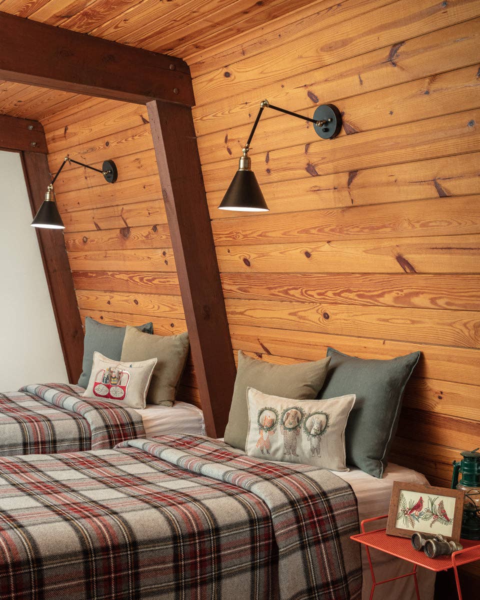 Wooden wall bedroom with plaid bedding and decorative pillows