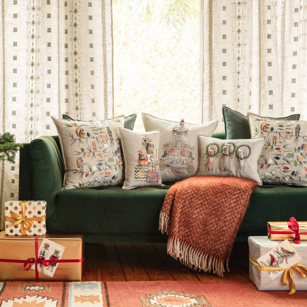 Living room with a decorated Christmas tree, green sofa, and wrapped gifts.
