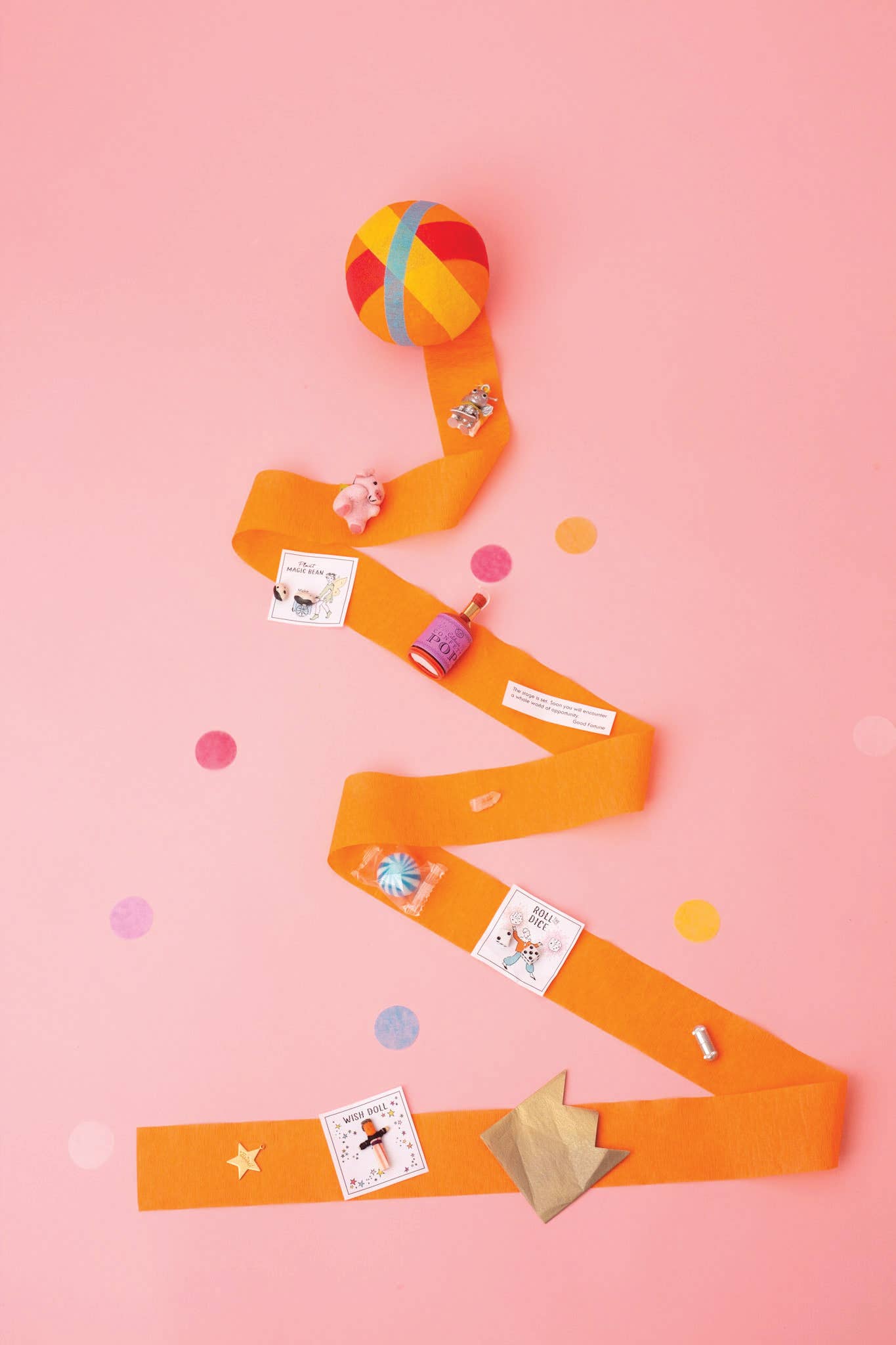 Colorful crepe string with small toys  on a pink background