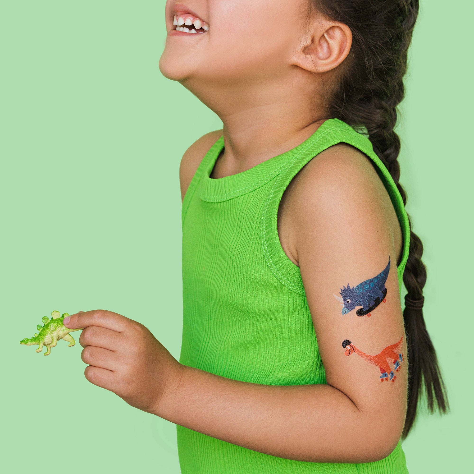 Child with dinosaur tattoos on a green background