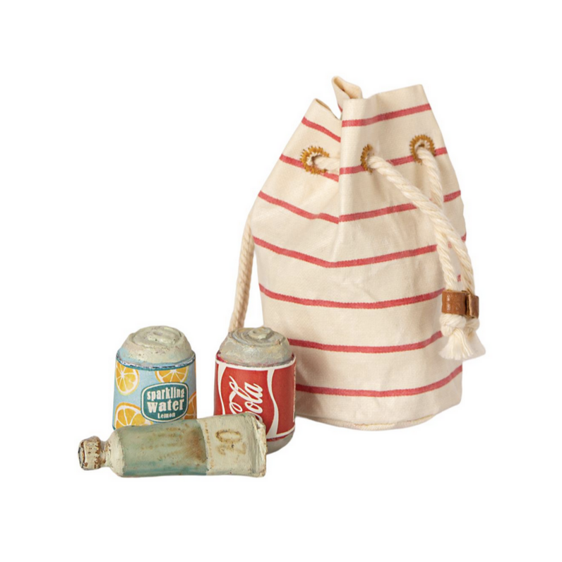 reda nd white striped beach bag wth two cans of soda and a sunscreen tube