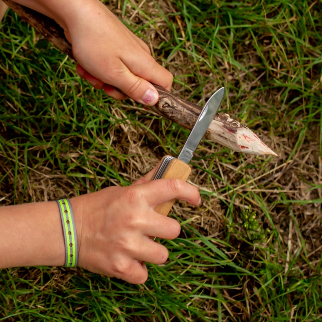 childs hands scraping stick with knife