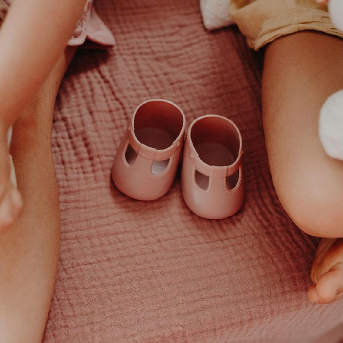 pink doll shoes on pink bed
