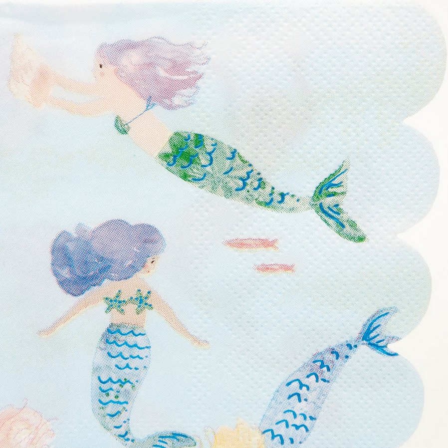 detail of mermaids swimming on blue scalloped napkins