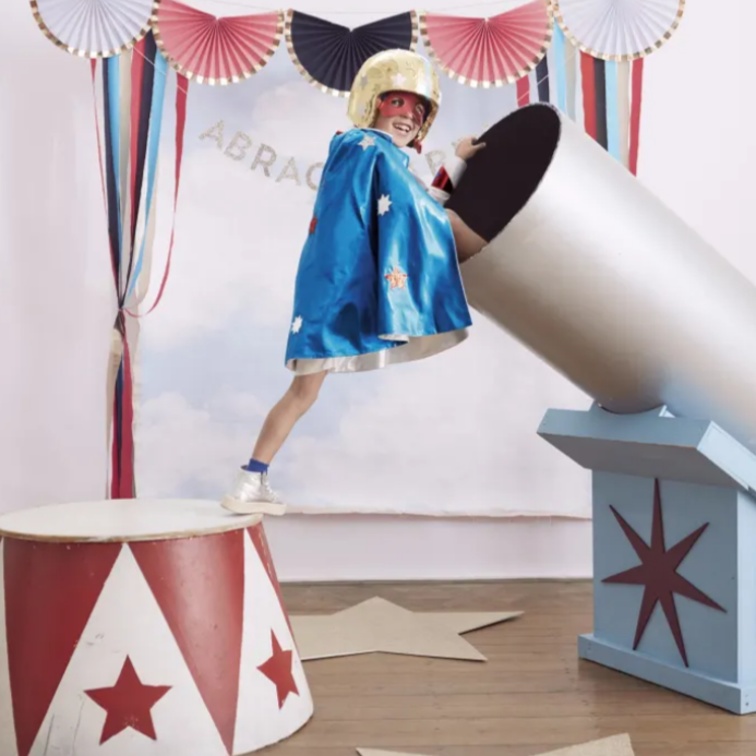 child wearing super hero costume in a circus setting
