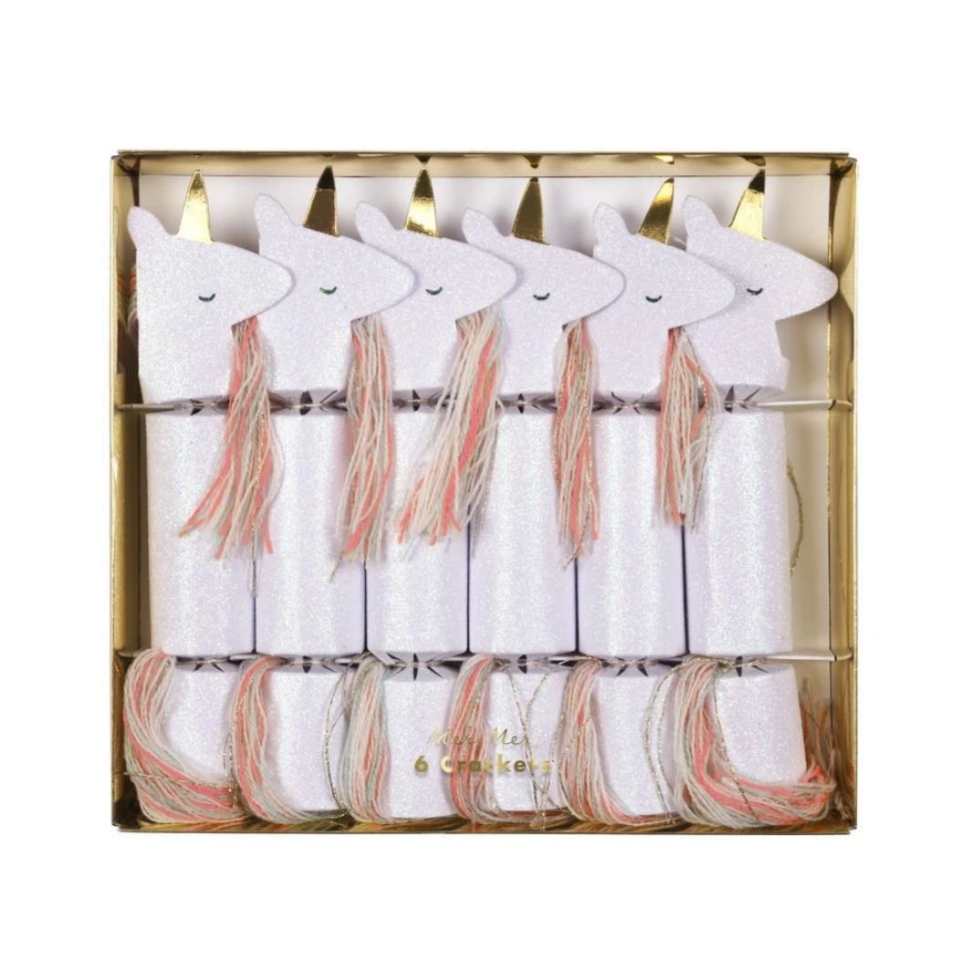 A set of unicorn-shaped glitter crackers with yarn manes and tails, embellished with crystal glitter and gold foil, containing enamel hair slides, paper hats, and jokes.