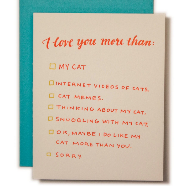 Greeting card with the title 'I love you more than my cat' with a list of options to express this love, such as 'MY CAT', 'INTERNET VIDEOS OF CATS', 'CAT MEMES', 'THINKING ABOUT MY CAT', 'SNUGGLING WITH MY CAT', 'OK, MAYBE I DO LIKE MY CAT MORE THAN YOU', 'SORRY'. The card is shown with a turquoise envelope.