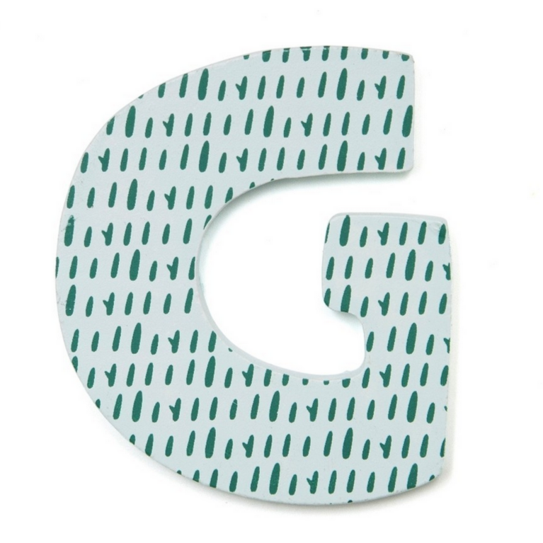 here is the letter G. It is wood and light blue and covered in bits of green grass.