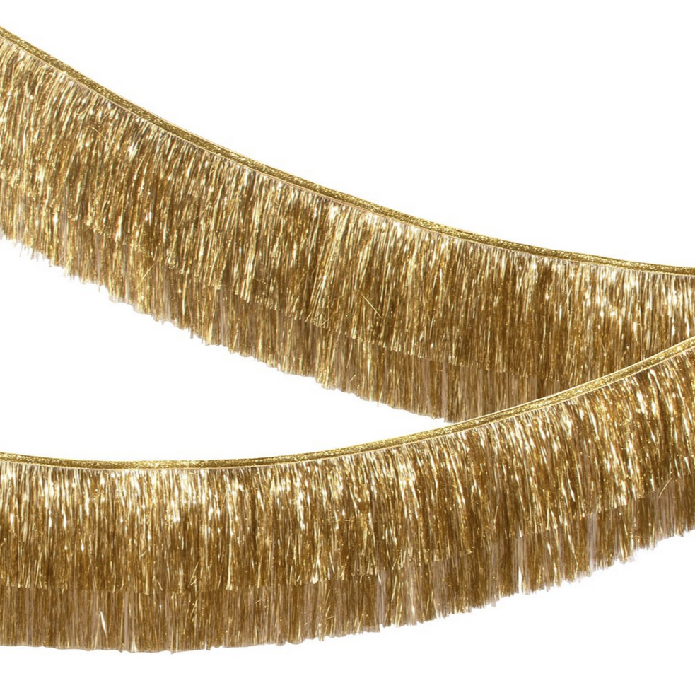 A gold tinsel fringe garland with ribbon ties and metallic thread detail, laid out on a plain background.