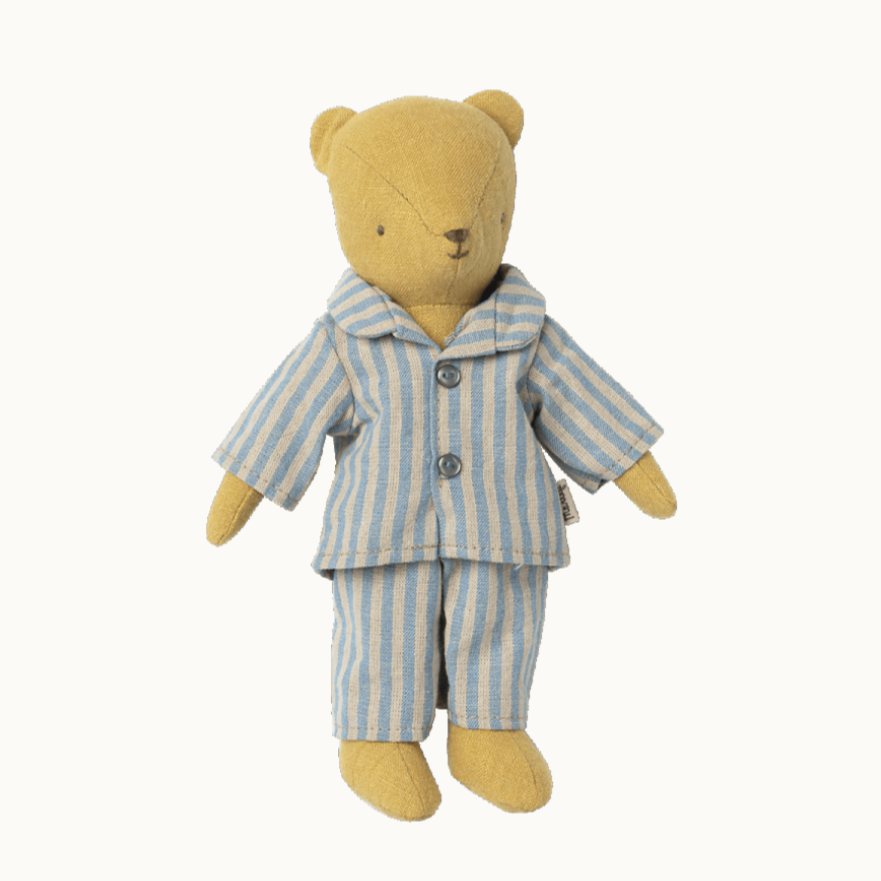 A small teddy bear wearing a blue and white striped pajama set.