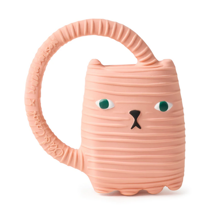 A pink silicone teether in the shape of a cat with a long tail handle, featuring green eyes and a smiling face.
