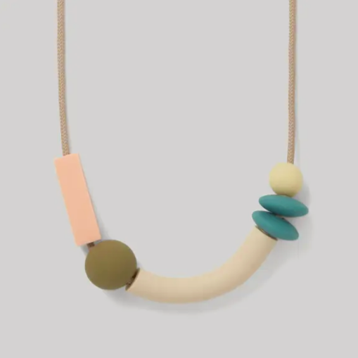 A teething necklace with a series of rounded silicone beads in shades of blue, green, beige, and pink strung on a beige cord.
