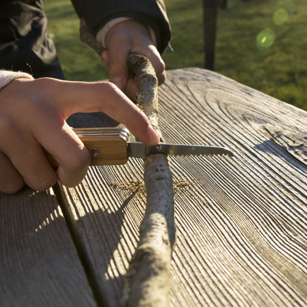 childs hands sawing through stick