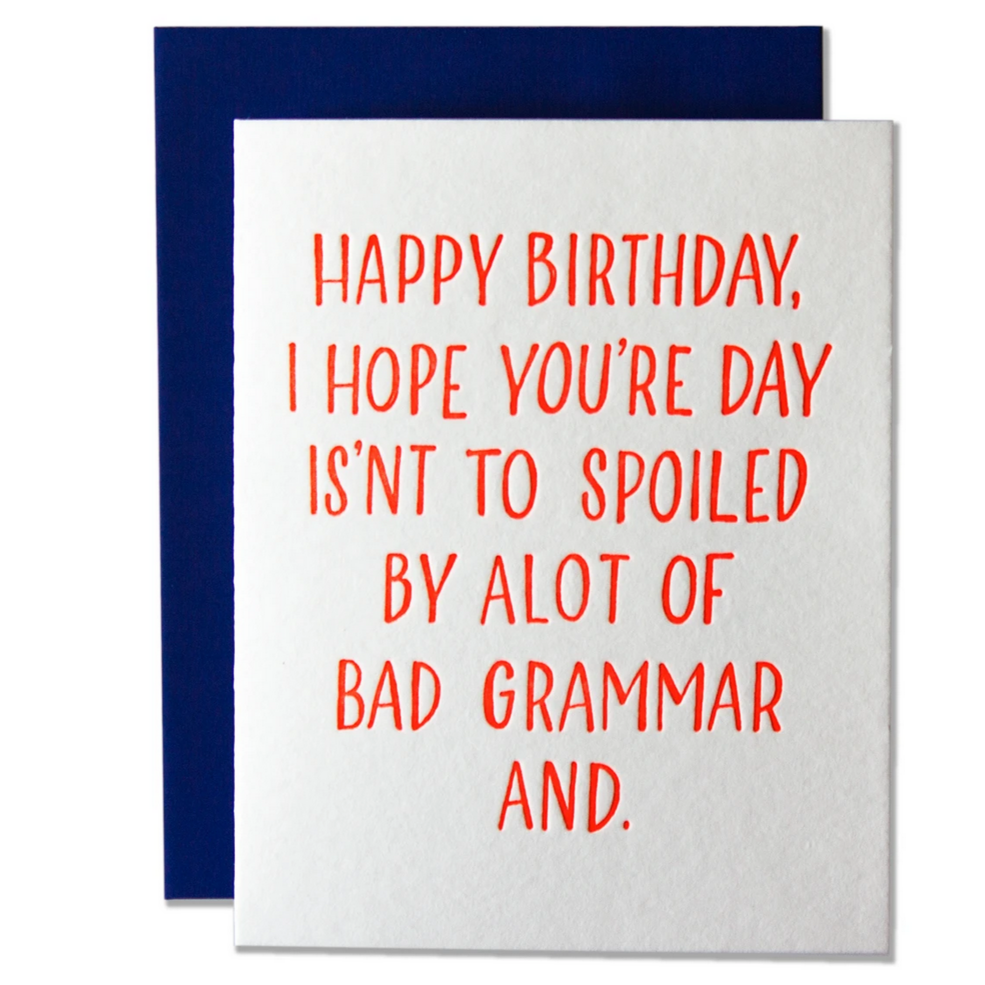 A greeting card with red text 'HAPPY BIRTHDAY, I HOPE YOU'RE DAY ISN'T TO SPOILED BY ALOT OF BAD GRAMMAR AND.' printed on it, with a blue envelope in the background.