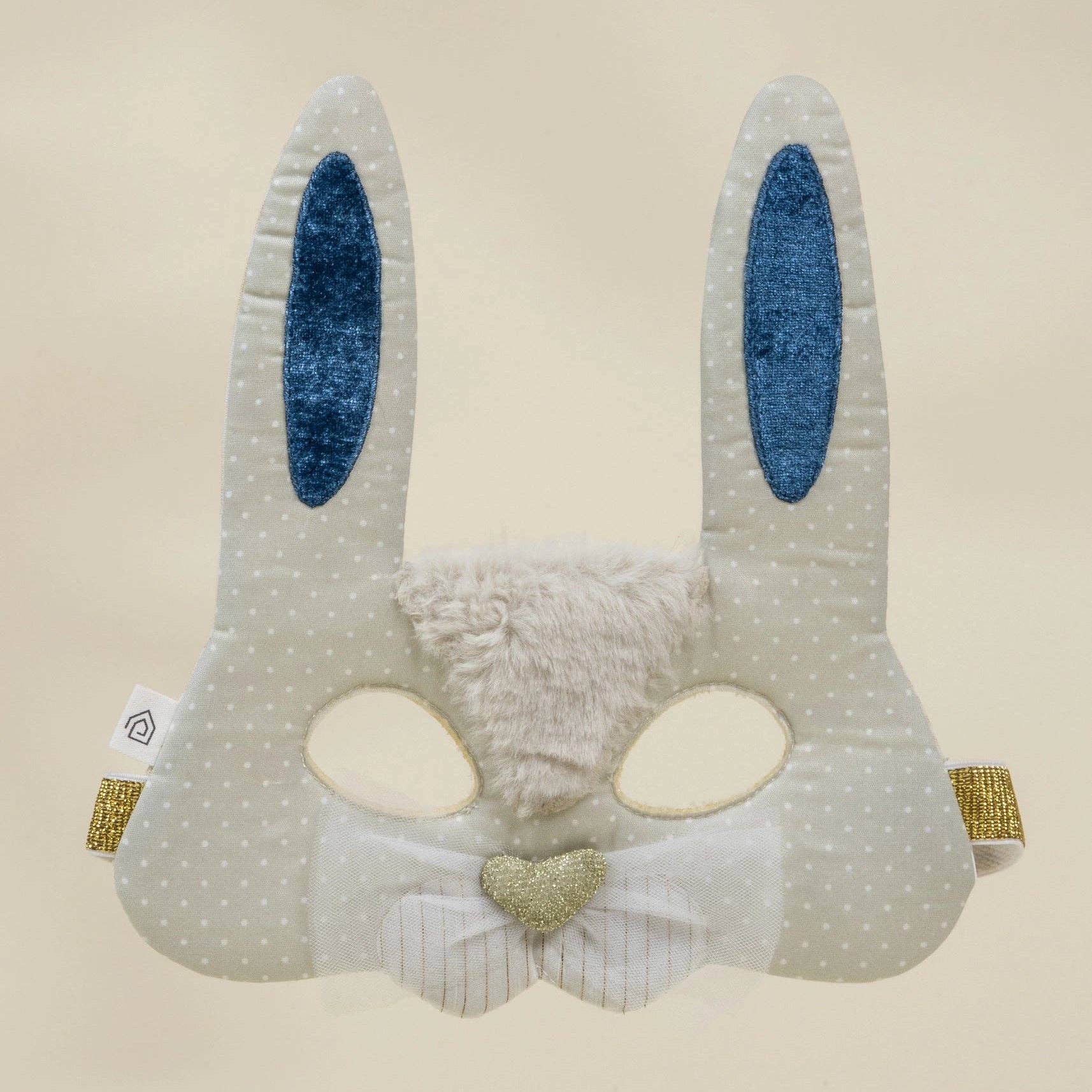Children's bunny mask with blue ears and a heart detail on a beige background