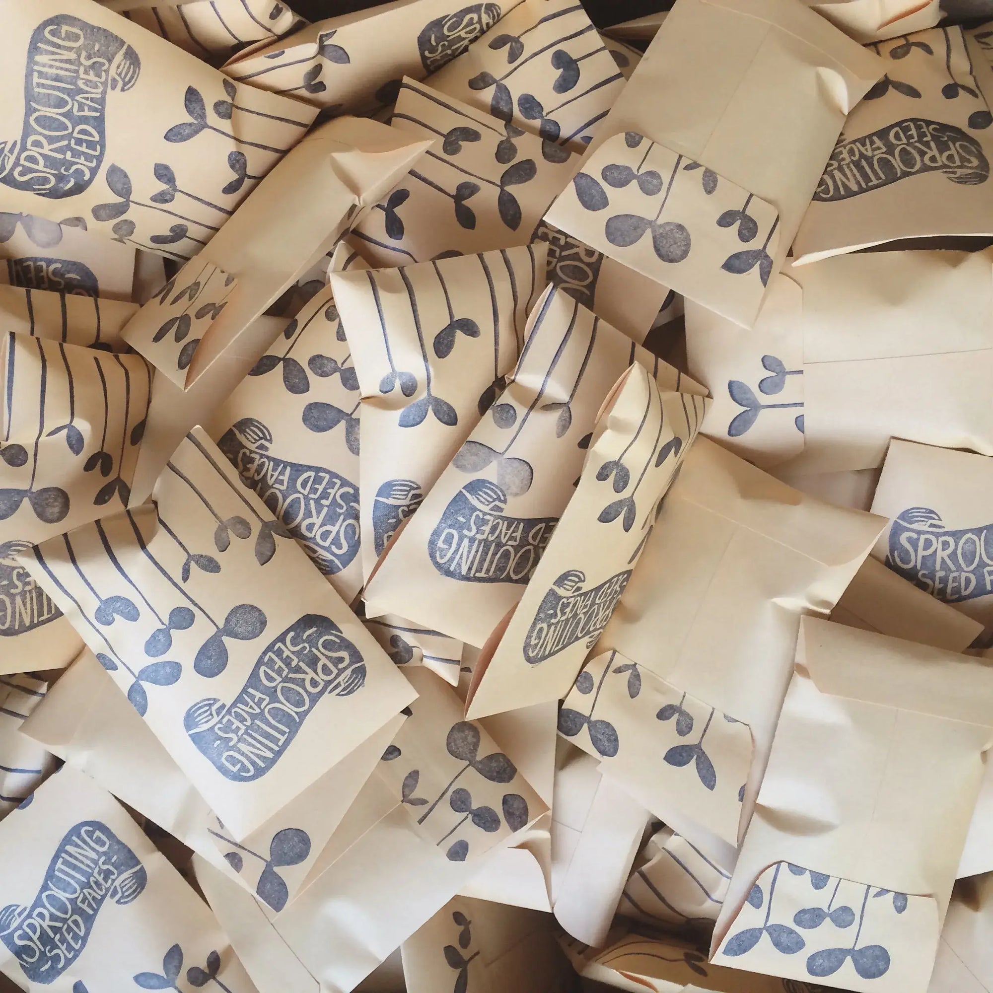 Pile of Sprooting Seed Paks packaging with blue text and graphics.