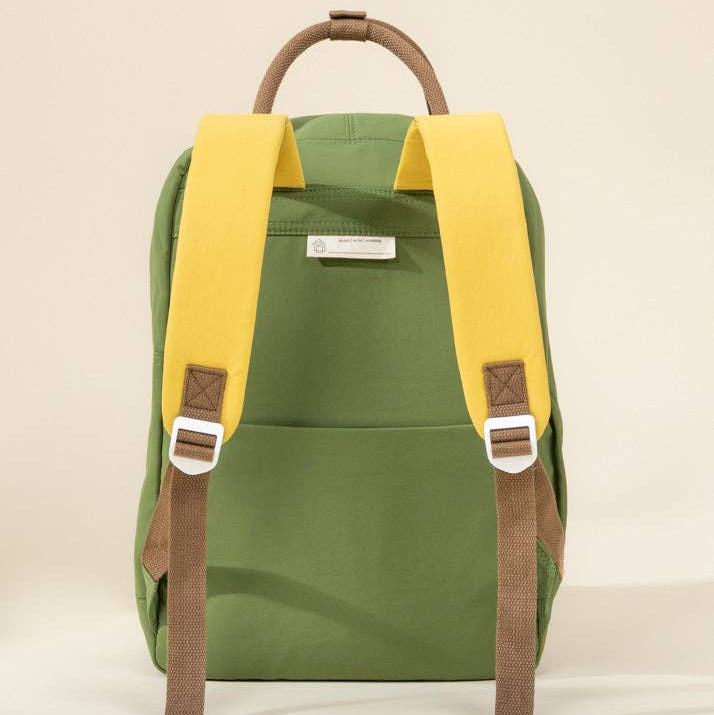 Green backpack with yellow straps on a beige background