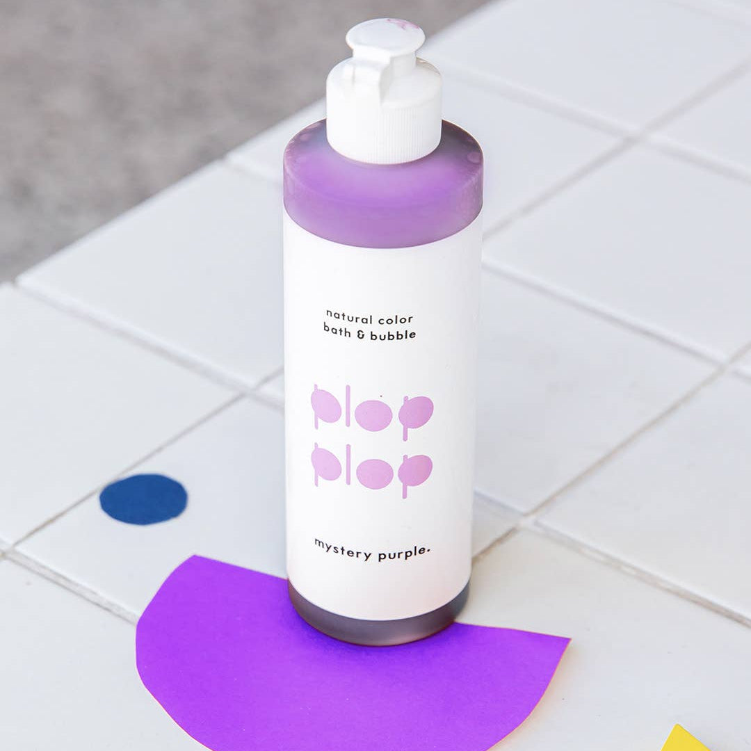 Bottle of bath and bubble product with a purple label on a tiled floor