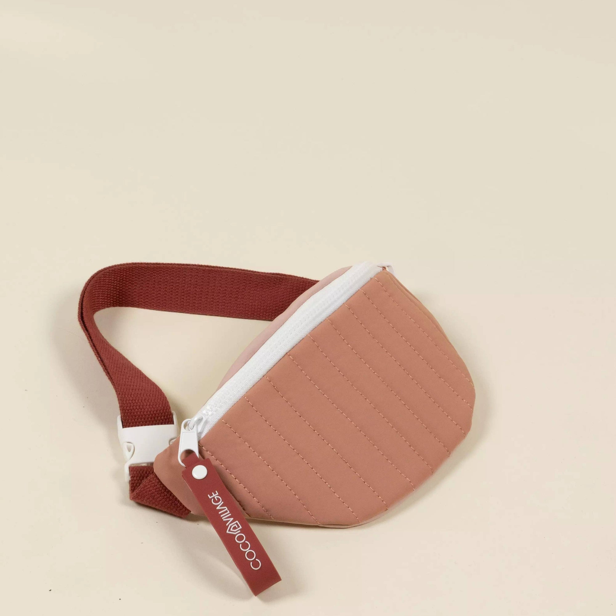 Brown belt bag with a strap on a beige background