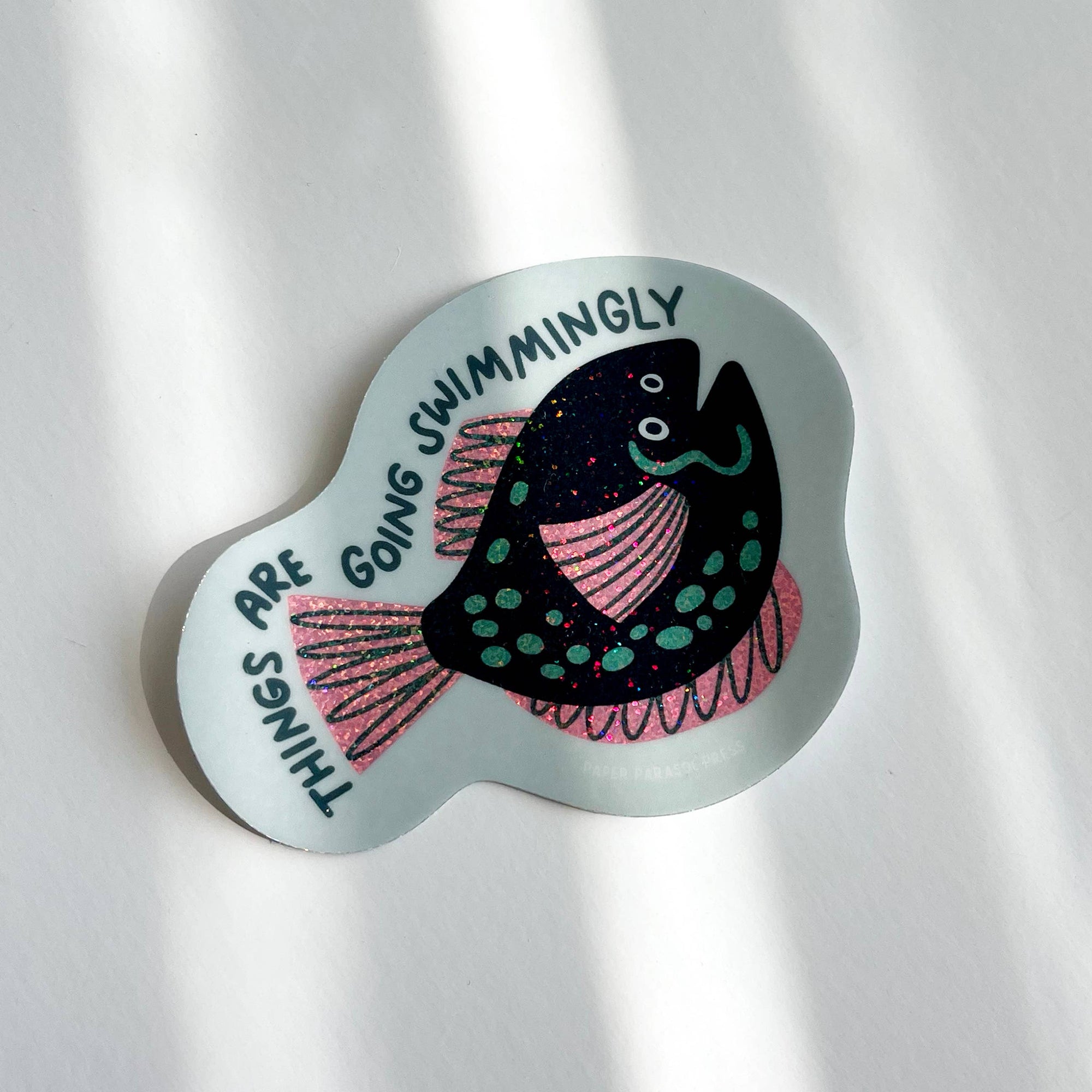 Decorative sticker with a fish illustration and text on a light gray background