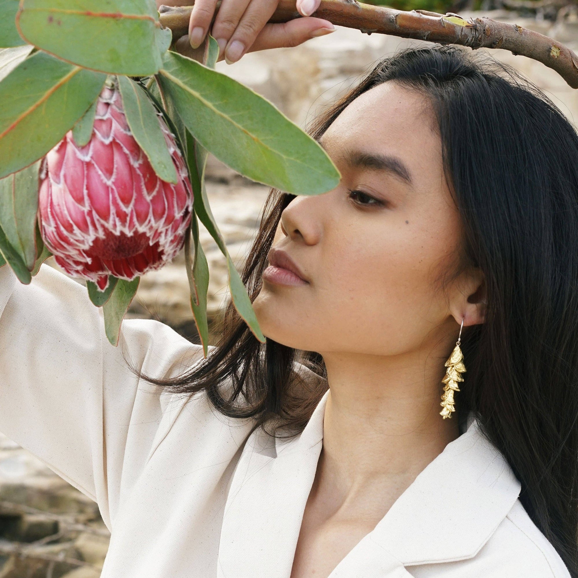 Woman holding a large pink flower with a natural background